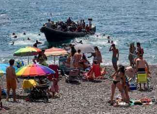 España, un Gobierno ausente donde nadie controla la llegada de inmigrantes: una patera desembarca a plena luz del día en medio de los turistas